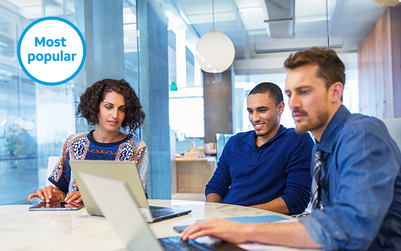 A group of business employees on computers utilizing AT&T Business Fiber Internet services to stay connected