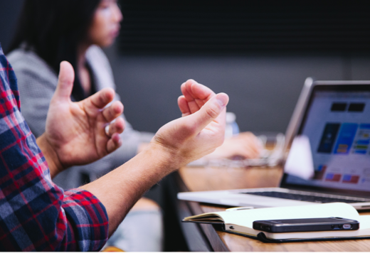 Man working on a laptop and explaining to audience.